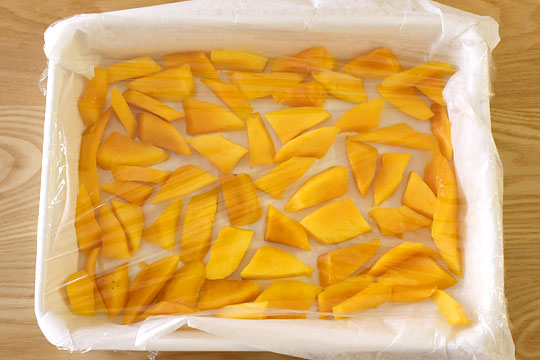 マンゴーのバラ凍結の方法　バットにクッキングシートを敷き果物を並べラップをかける