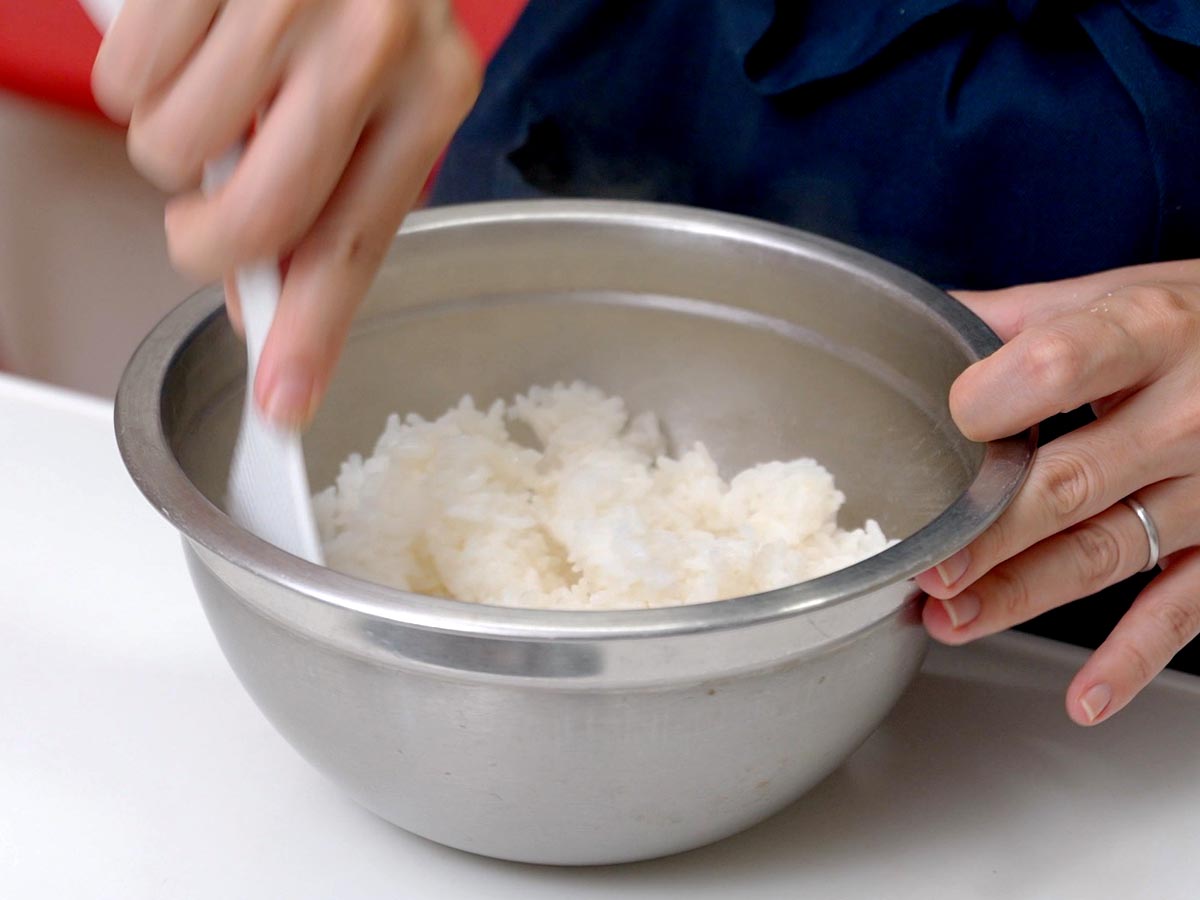 ご飯に、塩少々とごま油を加えよく混ぜ合わせる