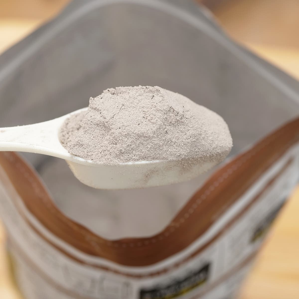 NUTO ホエイプロテインパウダー ミルクチョコ味 1000g スプーンですくった