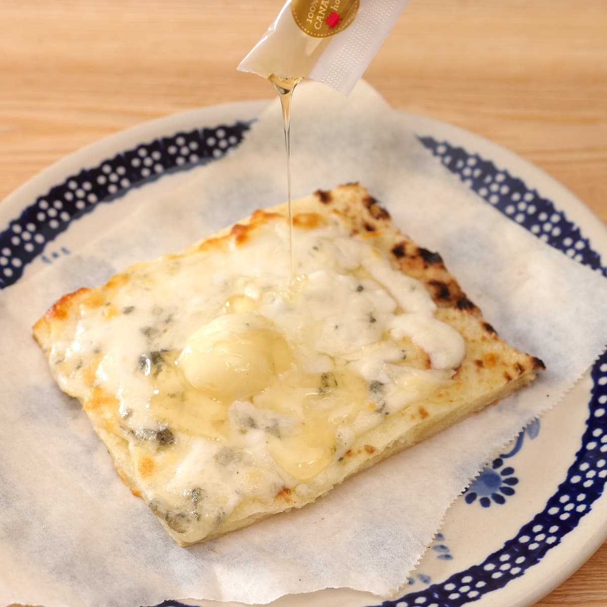 チーズとはちみつのピザ　はちみつをかけている様子